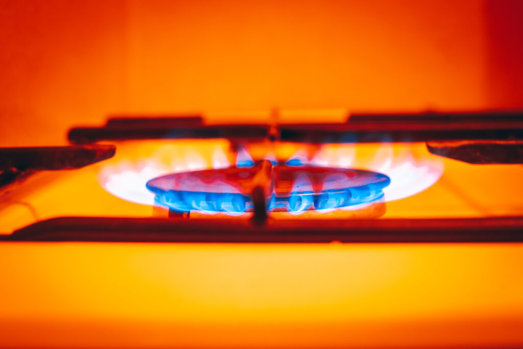 flaming gas in an apartment stove, Close-up, strongly warm colors, Household energy price concept